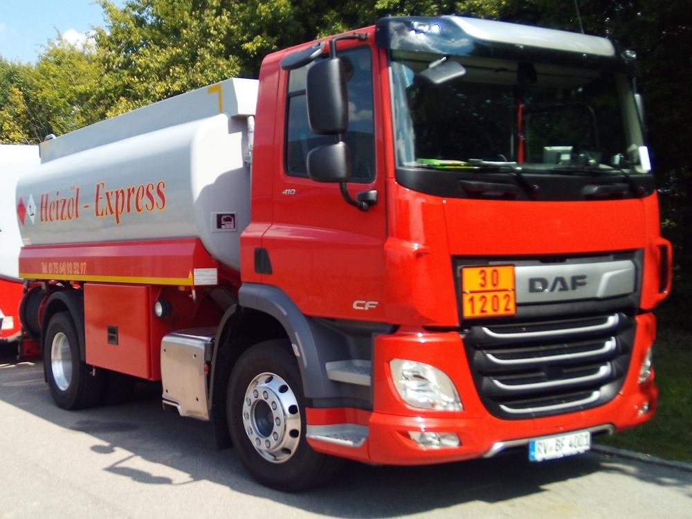 Rotes Fahrerhaus eines DAF Tankwagens von vorne schräg, dahinter der silberne Tank mit der Aufschrift Heizöl-Express und die orangefarbene Gefahrgut-Tafel